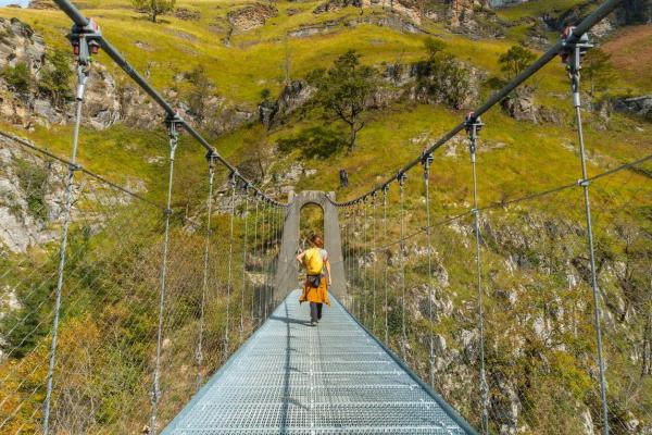 Mujer atravesando un puente colgante